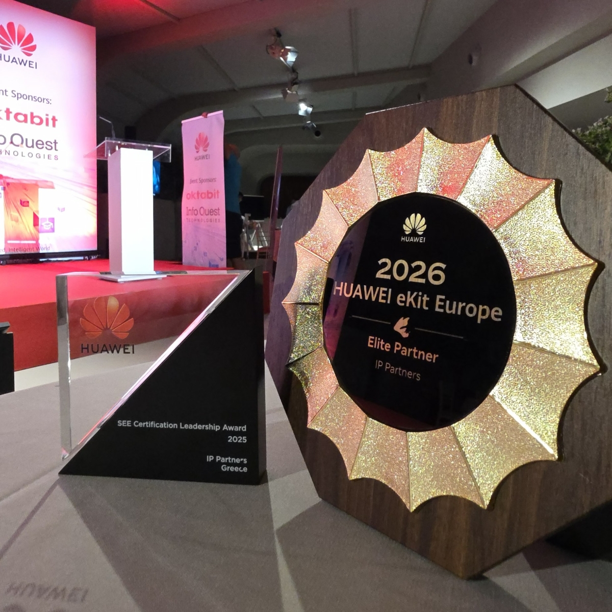 Two Huawei awards displayed side by side: the 2025 SEE Certification Leadership Award crystal trophy and the 2026 HUAWEI eKit Europe Elite Partner plaque presented to IP Partners.